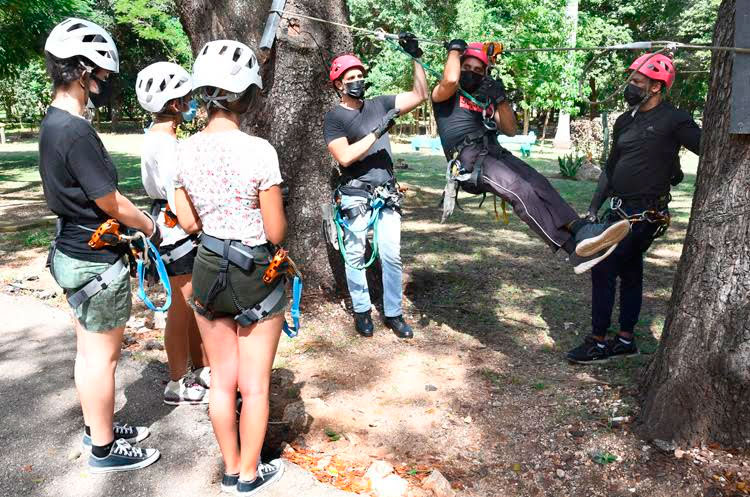 Tres jóvenes (I) recibiendo instrucción previo a dar un salto de canopy tour en el Parque Ecológico de La Habana, conocido popularmente como "Monte Barreto", en La Habana, el 6 de noviembre de 2021. Foto: Joaquín Hernández Mena/Trabajadores