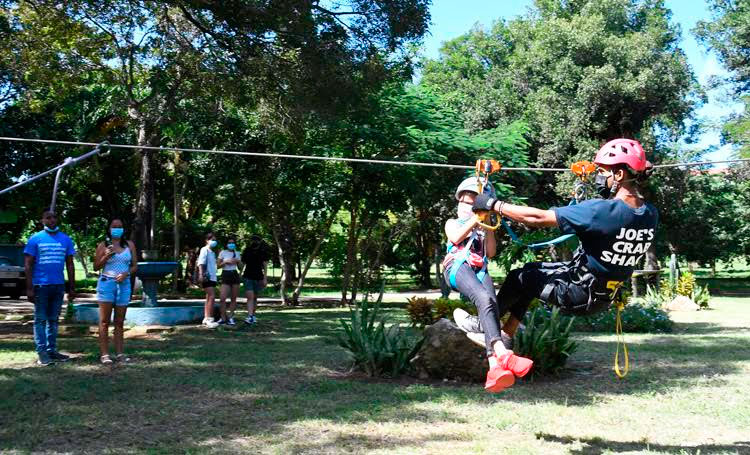 Una niña ayudada por un guía disfruta de un salto del canopy tour en el Parque Ecológico de La Habana, conocido popularmente como "Monte Barreto", en La Habana, el 6 de noviembre de 2021. Foto: Joaquín Hernández Mena/Trabajadores