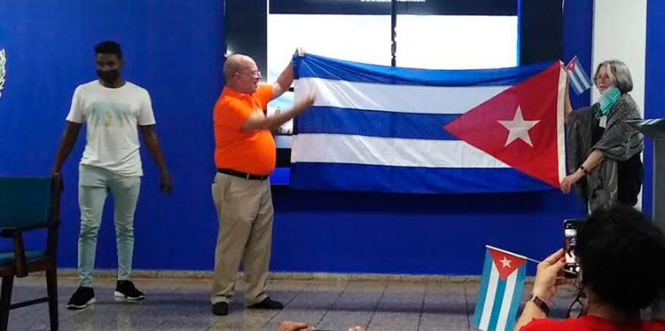 Cheryl LaBash, de la Red Solidaridad Cuba-EE. UU. recibió, en nombre de la caravana de los Pastores por la Paz, una bandera cubana. Se la entregó, Edel García, director de la EIE.