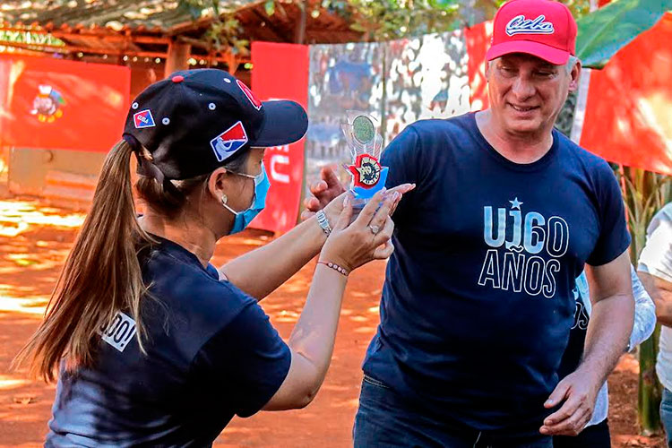 Aylin Álvarez, primera secretaria de la UJC, entregó a Díaz-Canel la moneda conmemorativa de los 60 años de la organización política, como reconocimiento a su trayectoria como dirigente juvenil. Foto: Heriberto González Brito