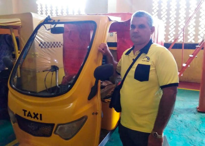 Yuris Miguel Almanza Corzo junto a su mototaxi, con la cual laboró por más de 12 horas diarias durante un año para apoyar a los centros de aislamientos. Foto: Gretel Díaz Montalvo