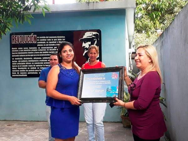 La secretaria general de la CTC en Las Tunas, Odalis Batista Pérez, entrega certificado de reconocimiento. Foto: Cortesía de Ana Ivis García Rodríguez