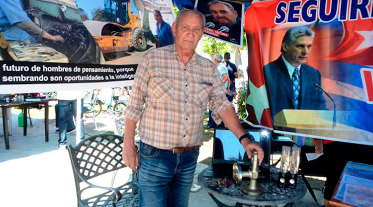 Ingeniero Juan Bravo Rodríguez junto al dispositivo en la Expo Anir efectuada en la provincia de Cienfuegos. Foto: Modesto Gutiérrez/ACN