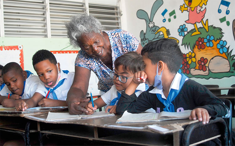 En un aula de tercer grado de la Escuela Especial José Briñas García, la maestra Enma brindando apoyo a los niños. Foto: Agustín Borrego