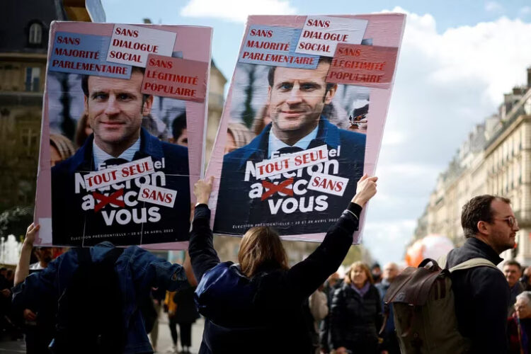 Uno de los carteles contra Macron enarbolado en las marchas dice: "Sin mayoría parlamentaria. Sin diálogo social. Sin legitimidad popular. Completamente solos, sin ti". Foto Reuters