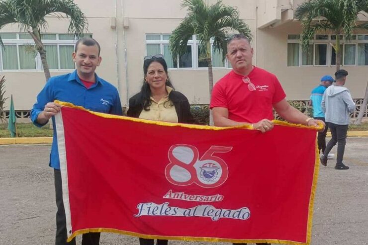 Yoanh David Pérez Sánchez, subdirector general del Royalton Hicacos, y el secretario general del buró sindical Amaurys Echevarría, muestran la Bandera, acompañados de Mailén Alemañy. Foto: Noryis